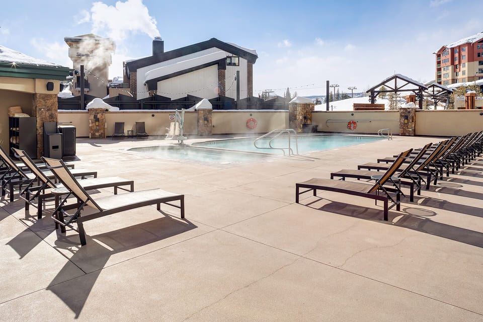 Soak up the sun on your private poolside lounger, where steaming waters and mountain views create your perfect retreat.