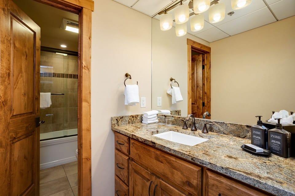Step into your private bathroom with warm wood accents, gleaming granite counters, and a spacious tub-shower combo—perfect for refreshing after a day of adventure.