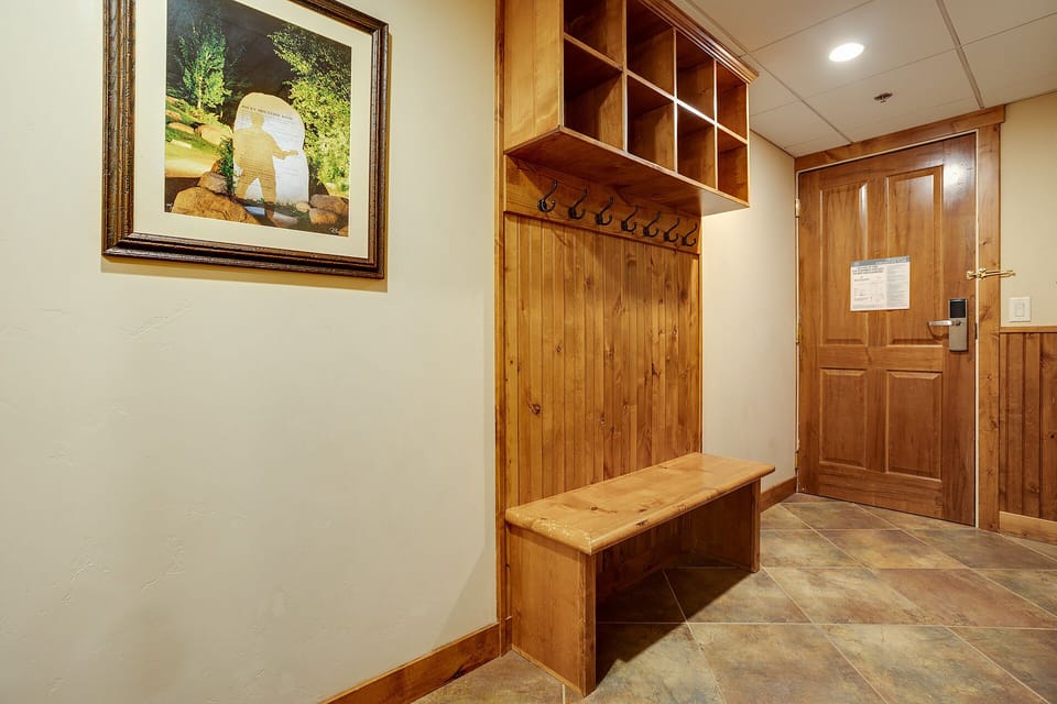 Step into your private mudroom with custom wooden storage cubby and bench—perfect for organizing gear after mountain adventures.