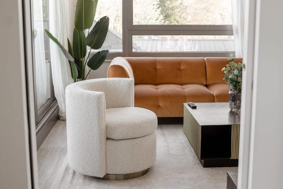 Chic lounge area with a caramel-toned sofa and cozy armchairs, perfect for reading, relaxing, or hosting guests