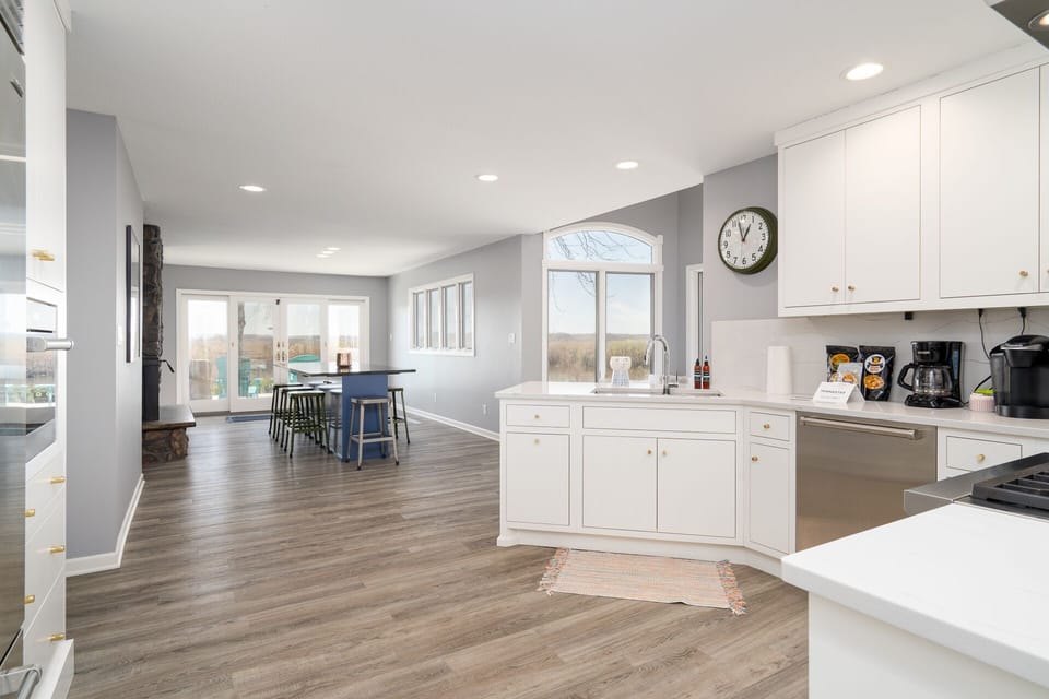 Your spacious open-plan kitchen flows seamlessly into the dining area, featuring white cabinets, modern appliances, and abundant natural light.