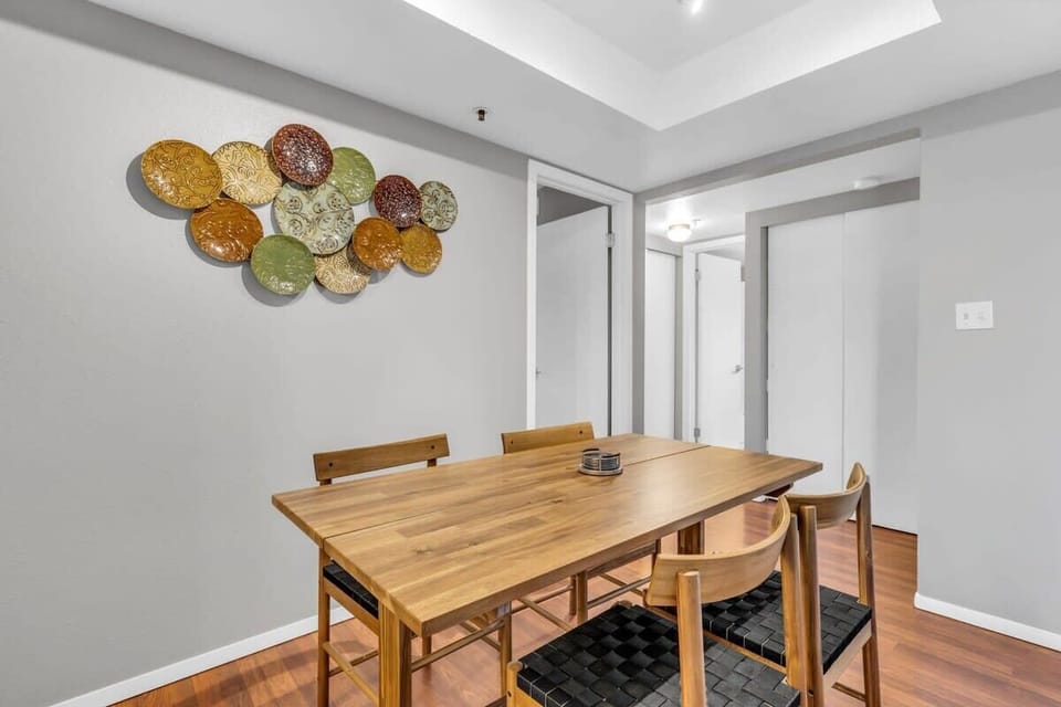 The dining area features a wood table with seating for four underneath a box vault ceiling.