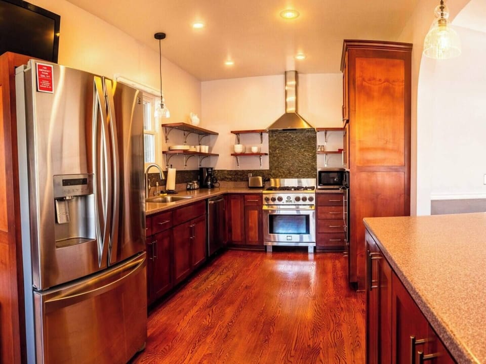 Fully stocked chef's kitchen with two ovens, dishwasher, microwave, refrigerator, and disposal. 