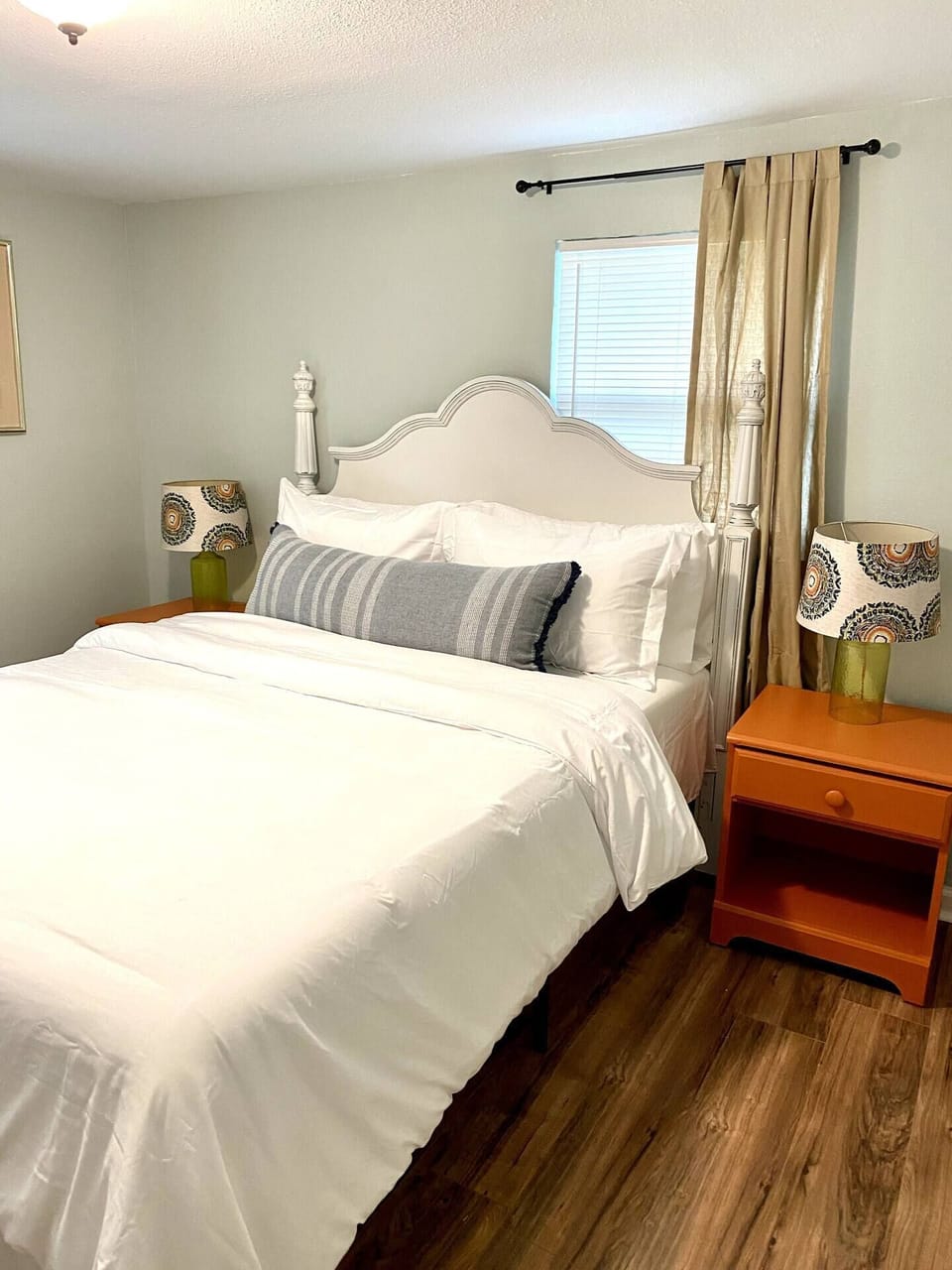 Simple and comfy bedroom features a queen size bed and 2 bedside table.