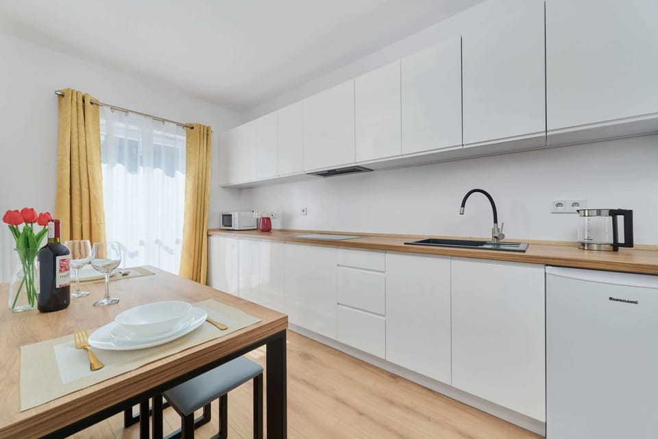Fully equipped kitchenette with fridge and freezer, electric hob, electric kettle, microwave and dining area.