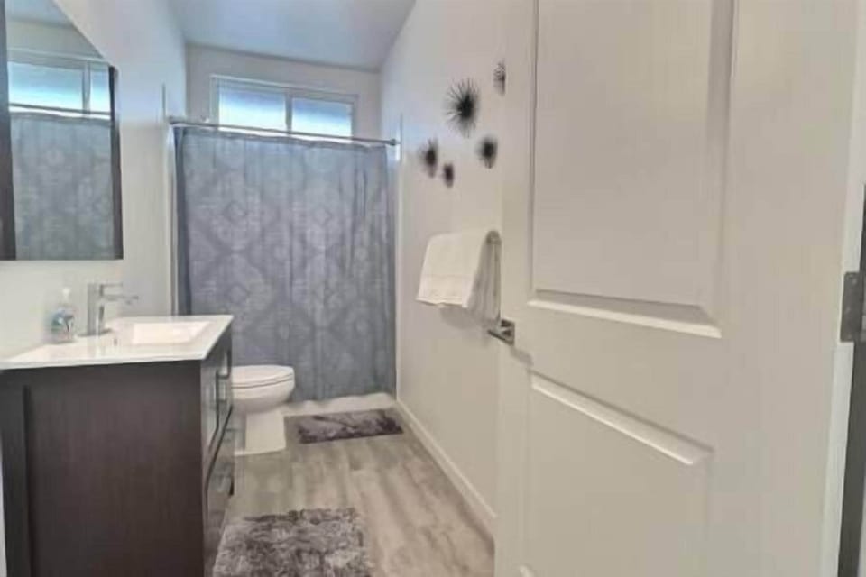 Spacious shared bathroom with shower/tub combo, large vanity, and all essential amenities.