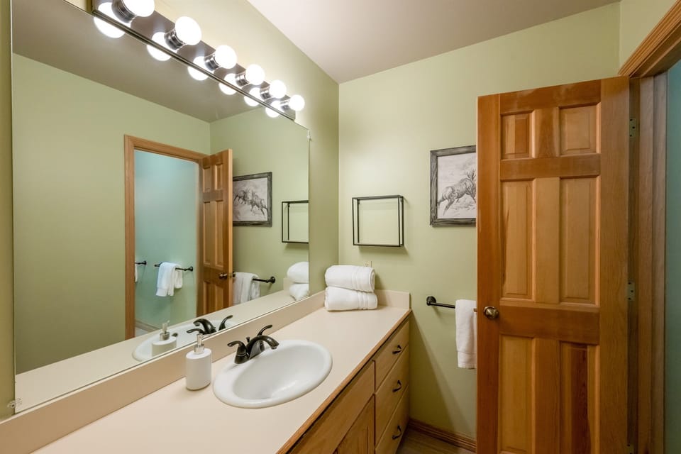 Lower-level bathroom is "jack and jill" style, connecting the lower living space and bunkroom