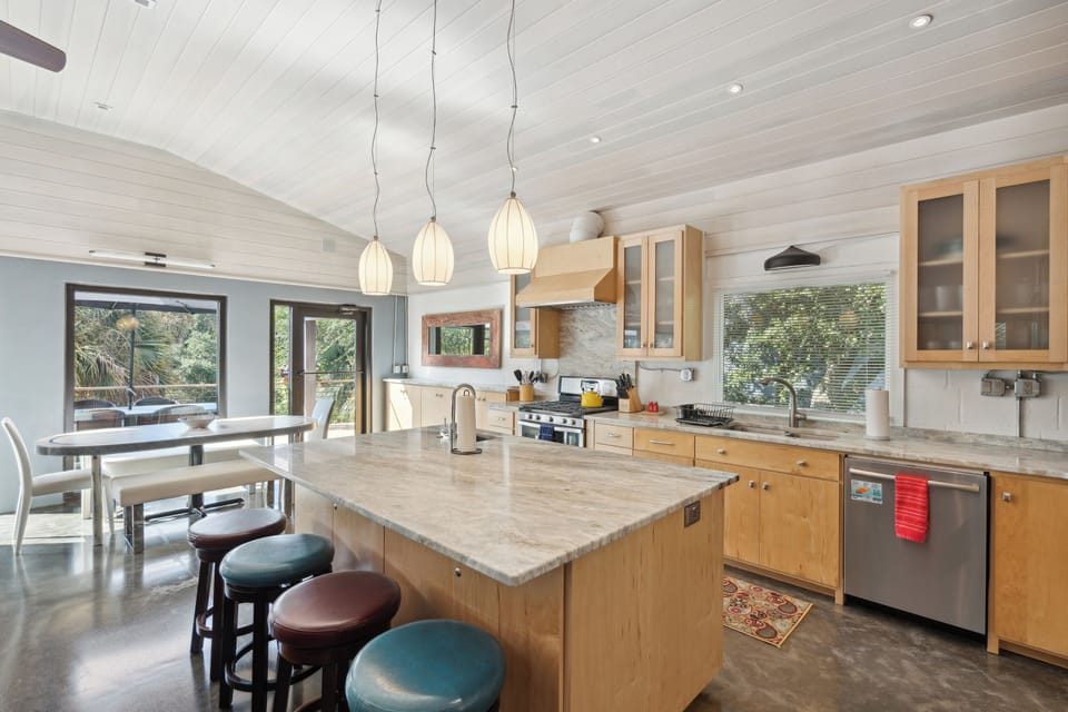 Full kitchen and modern appliances with a breakfast bar and dining area.