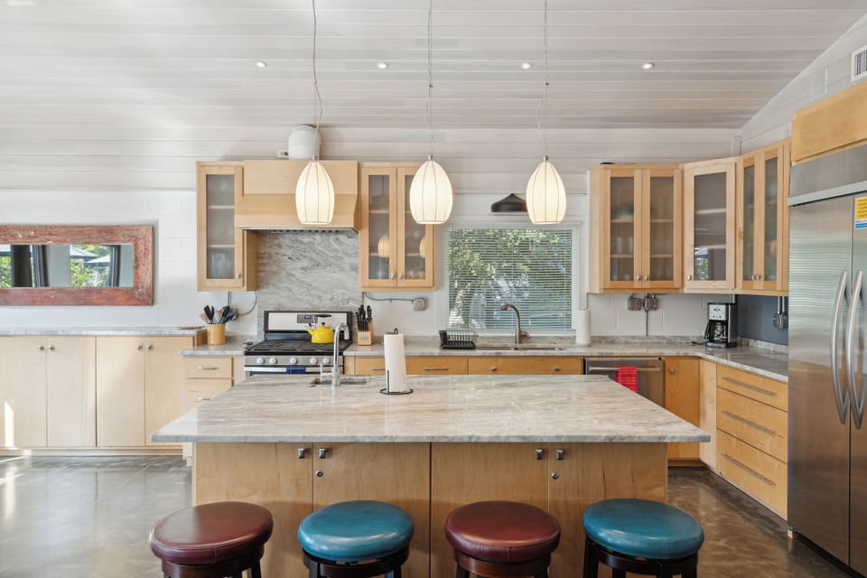 Full kitchen and modern appliances with a breakfast bar and dining area.