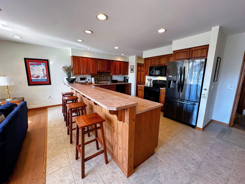 Fully equipped kitchen with modern cabinetry and a breakfast bar,