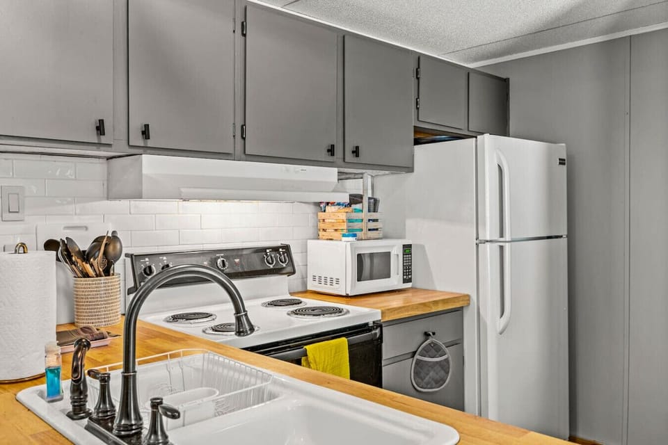 The kitchen includes an oven/stove, refrigerator, and microwave.