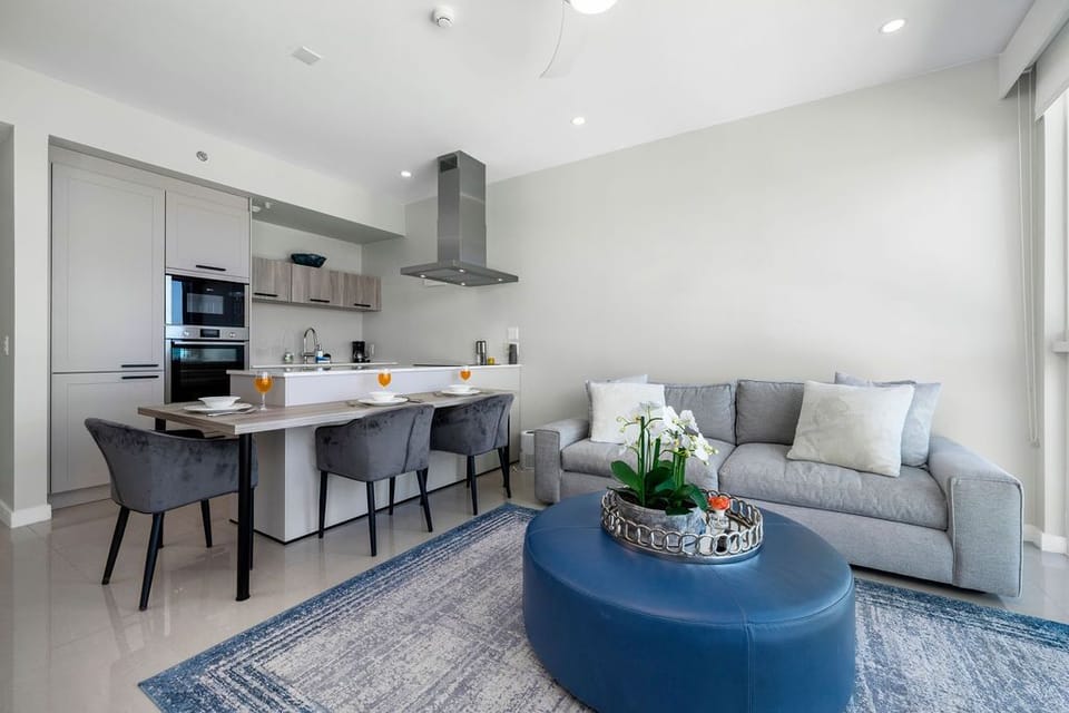 Relax in this stylish open-plan living space where your fully-equipped modern kitchen flows seamlessly into the inviting lounge, perfect for cooking, dining, and unwinding together in comfort.