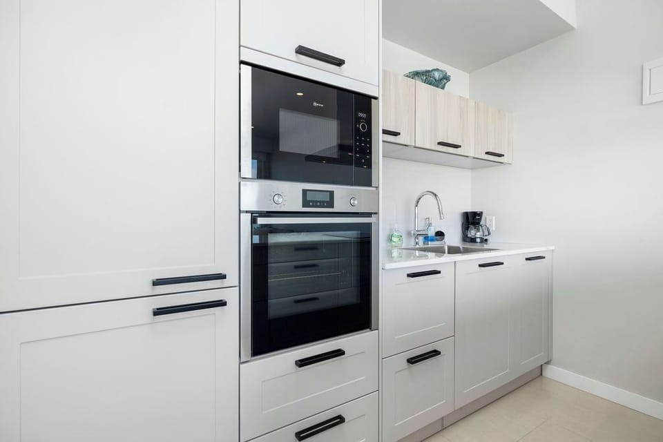 Your fully-equipped kitchen features sleek modern appliances, including a built-in oven, microwave, and coffee maker—everything you need to prepare fresh meals during your stay.
