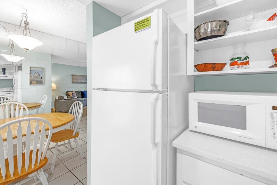 Full-sized fridge and turntable microwave oven.