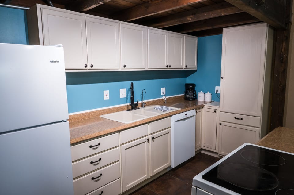 Kitchen with dishes, cookware, and appliances. 