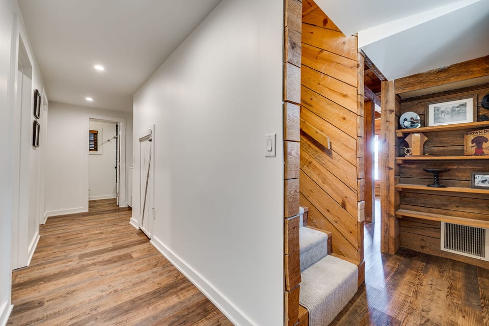 Carpeted stairs to basement w/ built-in baby gate at the top 