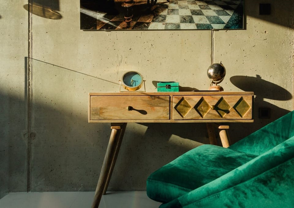 A green velvet chair and a wooden desk with drawers in the luxury villa Krk Baska II in Baška on the island of Krk