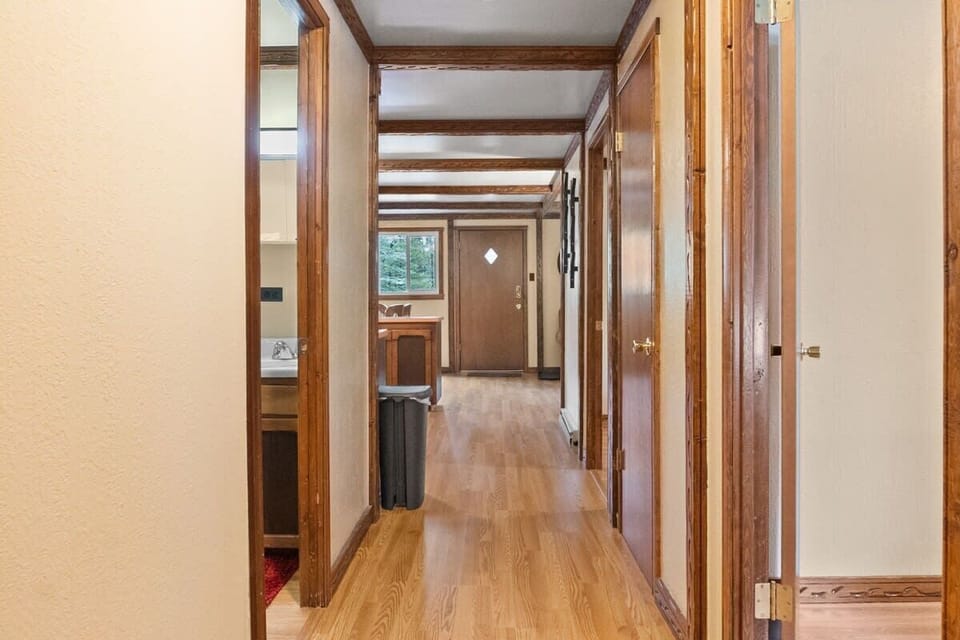 The view down the hallway from the bedrooms towards the open living room/dining room/kitchen.