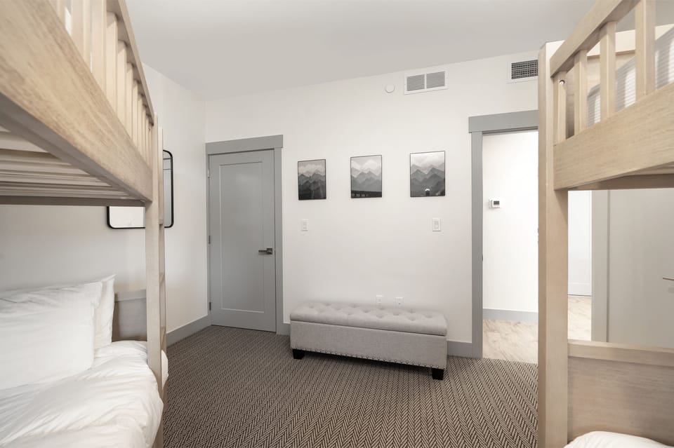 - Bunk bedroom with bench seating and wall decor   - Functional space with storage and cozy bedding   - Designed for families enjoying mountain retreat