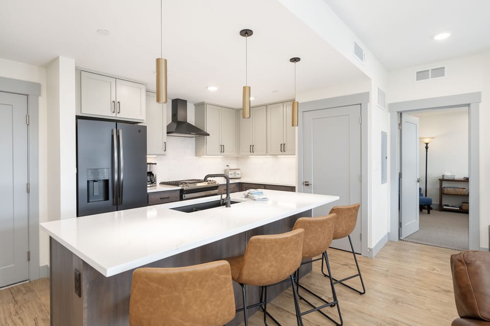 - Bright kitchen with large island and bar stools   - Stainless steel appliances and pendant lighting   - Designed for comfort and easy meal preparation