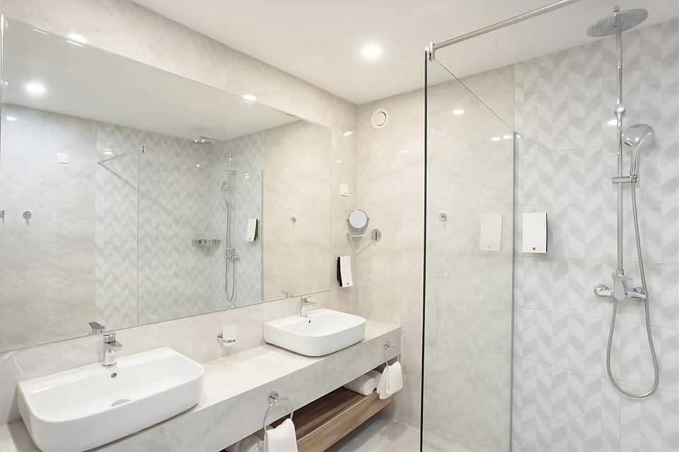Indulge in a spa-like rinse with double sinks and glass shower.