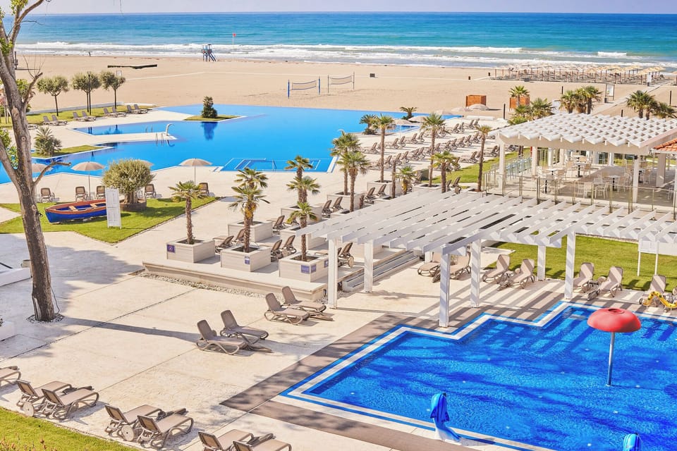 Soak up resort energy with pools, loungers, and beach ahead.