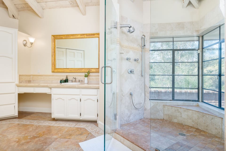 Primary bedroom's ensuite features a large shower with views.