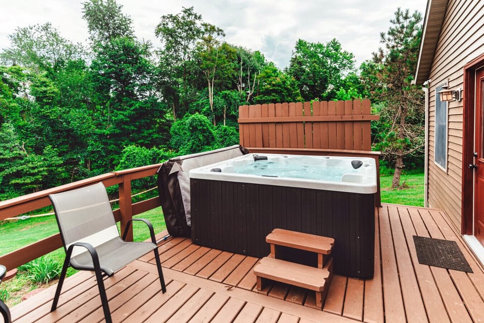 The spacious hot tub overlooking the timber on the back of the property.