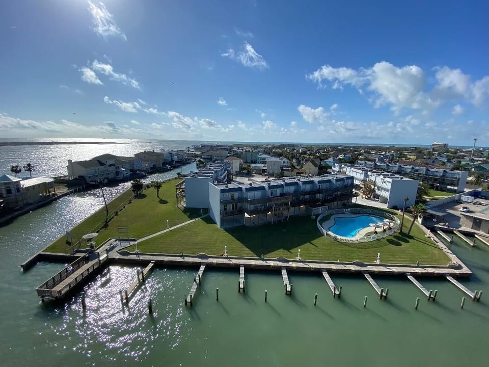 Stunning waterfront property features private marina access and sparkling pool surrounded by manicured grounds along pristine coastline.