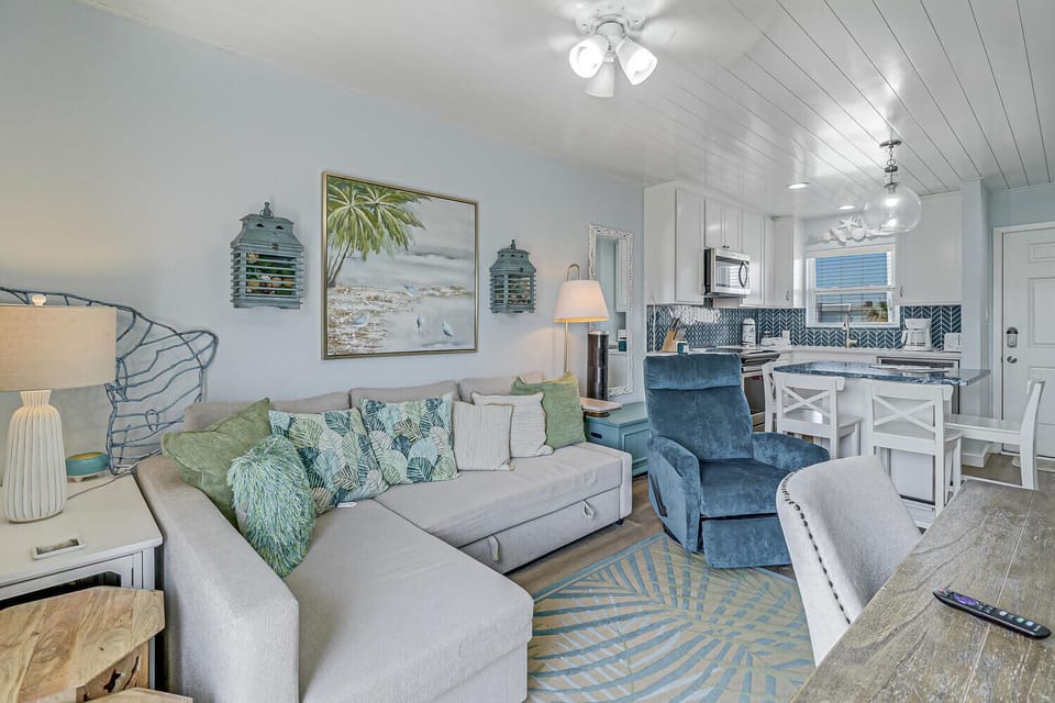 Sink into your coastal-inspired living space where ocean blues meet comfort. Unwind on plush seating while preparing meals in your stylish kitchen.