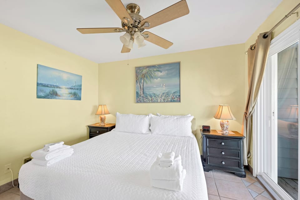 Wake up refreshed in your bright bedroom with coastal artwork, plush bedding, and gentle ceiling fan keeping you comfortable year-round.