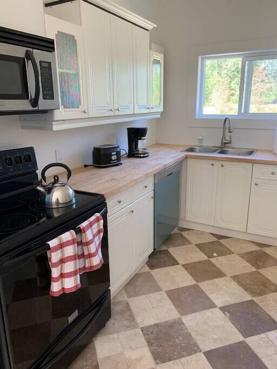 Kitchen with stove , fridge, dishwasher, microwave,, coffee maker, toaster and utensils 
