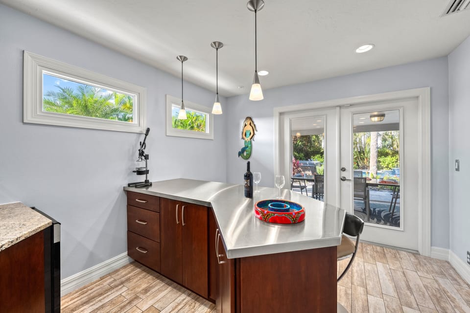 Pour a chilled glass from the wine fridge and step through French doors to the lanai, where indoor comfort meets breezy outdoor relaxation.