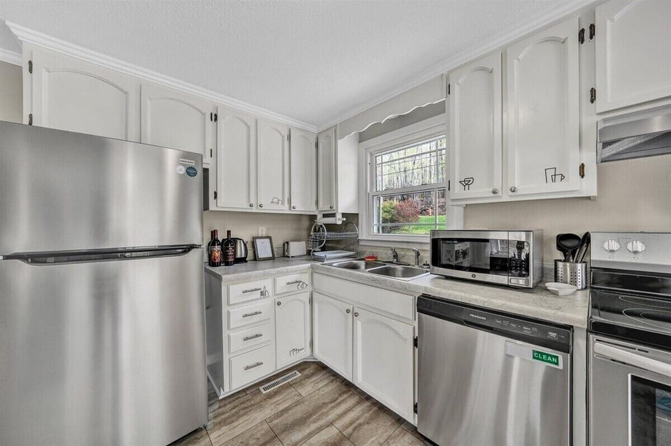 Modern kitchen with stainless steel appliances and ample natural light, perfect for cooking together
