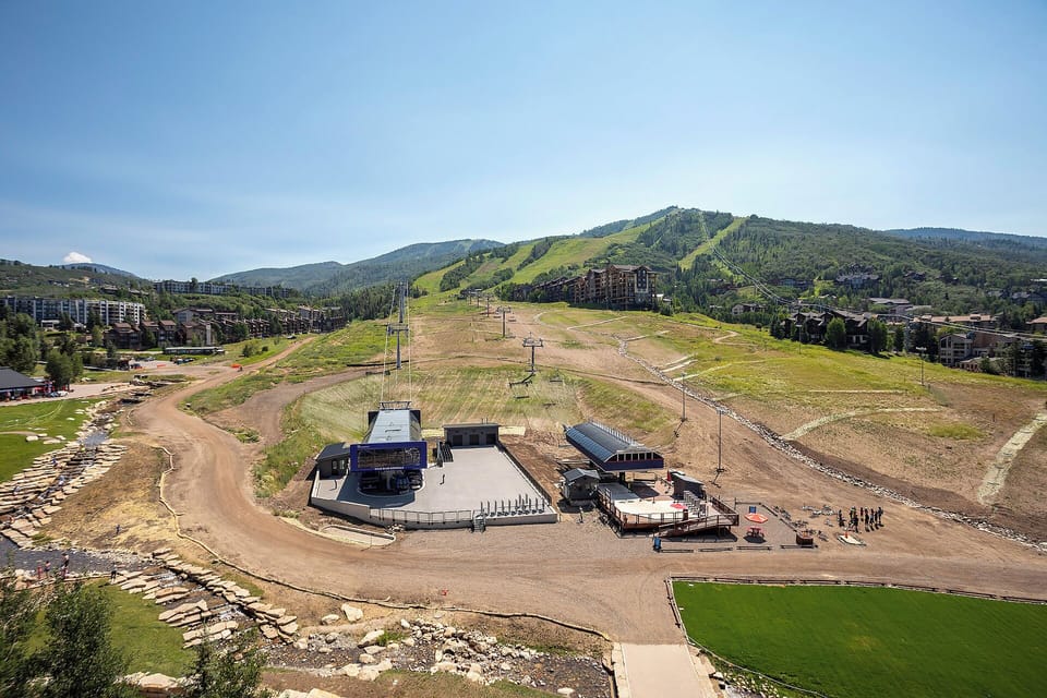 Mountain resort area with ski slopes and lift infrastructure surrounded by forested peaks and vacation accommodations.