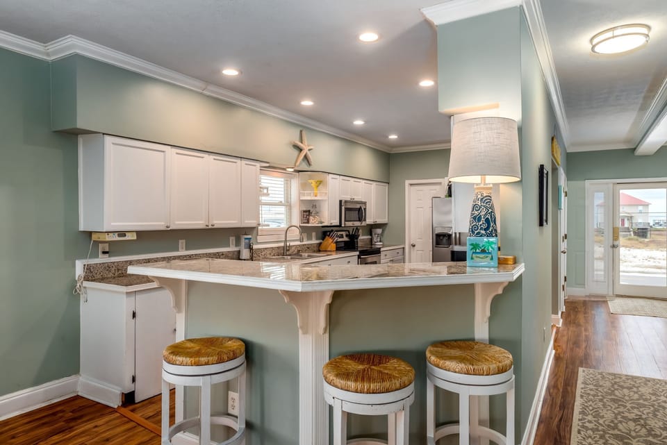 Gather around this spacious kitchen island where coastal charm meets modern convenience for memorable meal prep together.