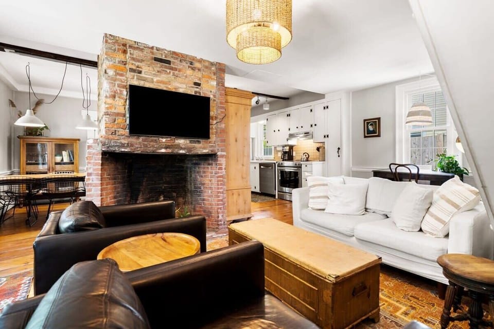Living room with smart TV, couch, accent chairs and dedicated "work-from-home" desk. The fireplace is inoperable.