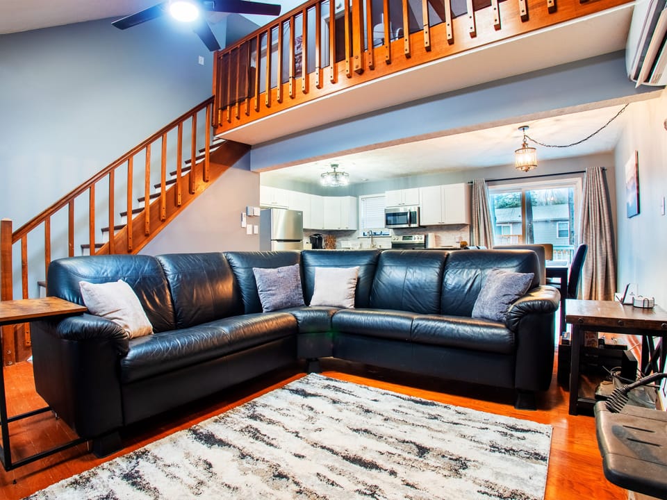 Spacious living room with 65" 4K Roku TV and sound-bar.