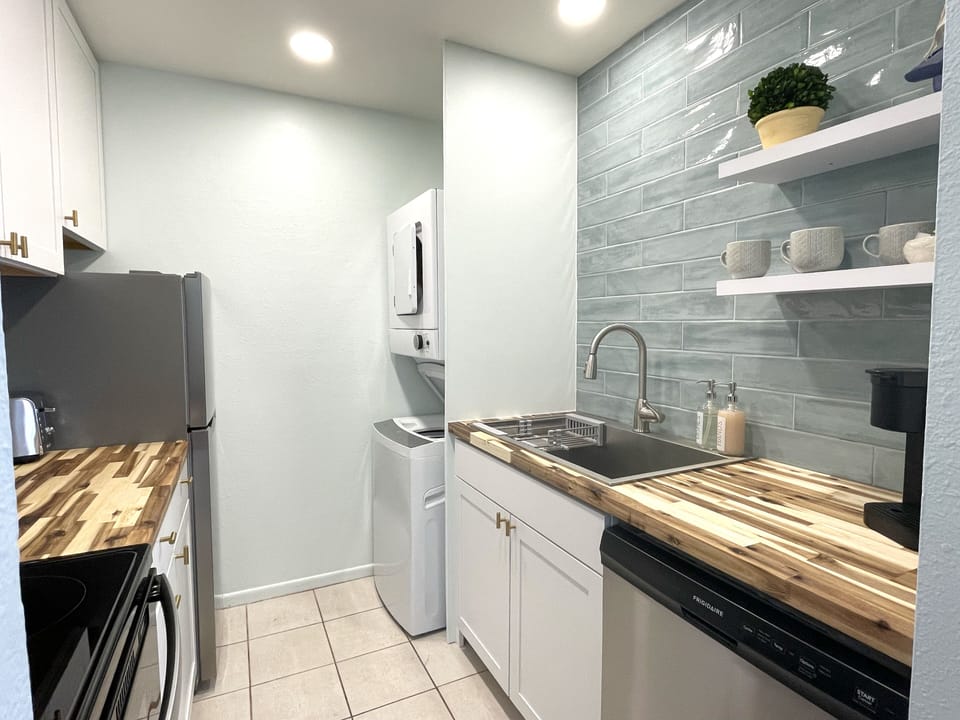 Kitchen, fully stocked with pots/pans, dishes, utensils. Washer/dryer is here