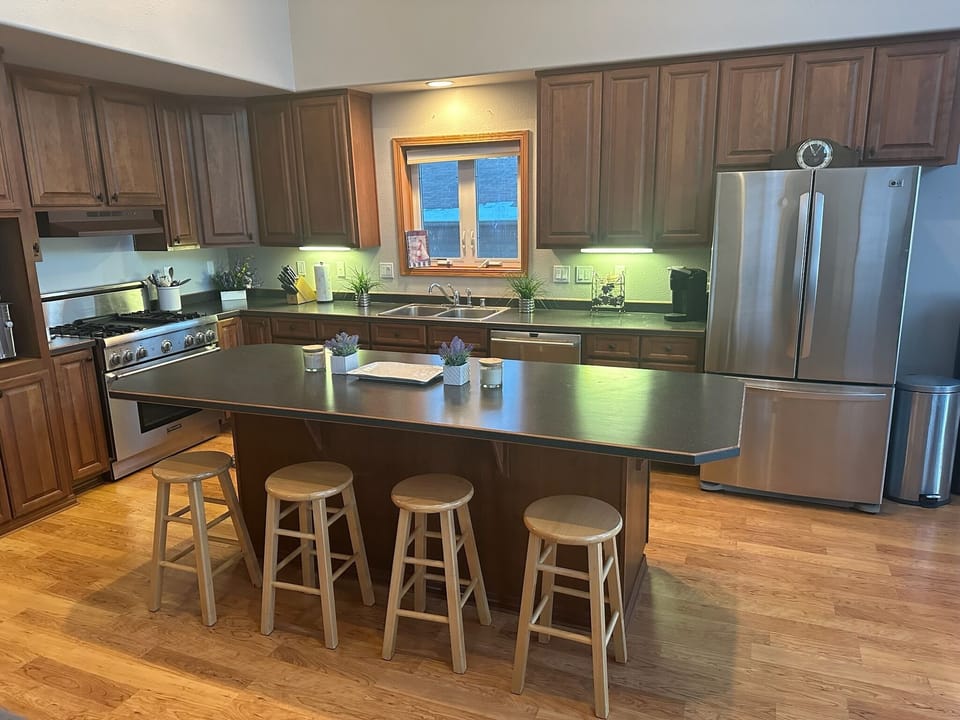 Full kitchen, appliances, bottled water dispenser, and extra seating for meals.