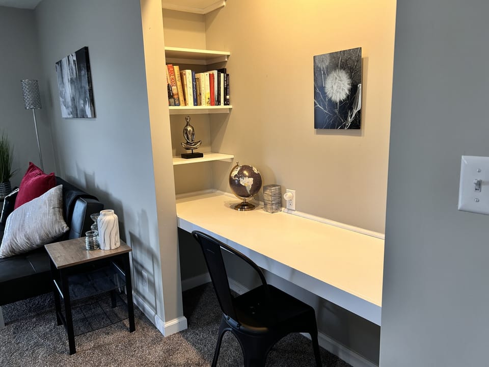 Work/desk space with USB outlets, bluetooth speaker and an assortment of books. 