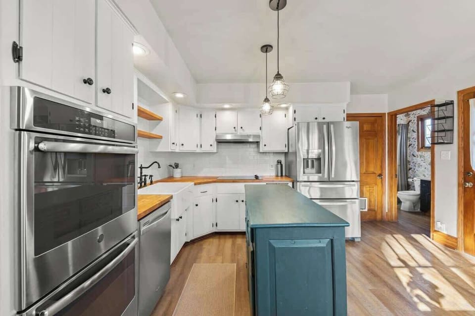 {KITCHEN} Experience culinary bliss in the beautifully equipped kitchen, complete with a farmhouse sink, glass top stove, double ovens, and a large French door fridge featuring filtered water and an ice maker. 
