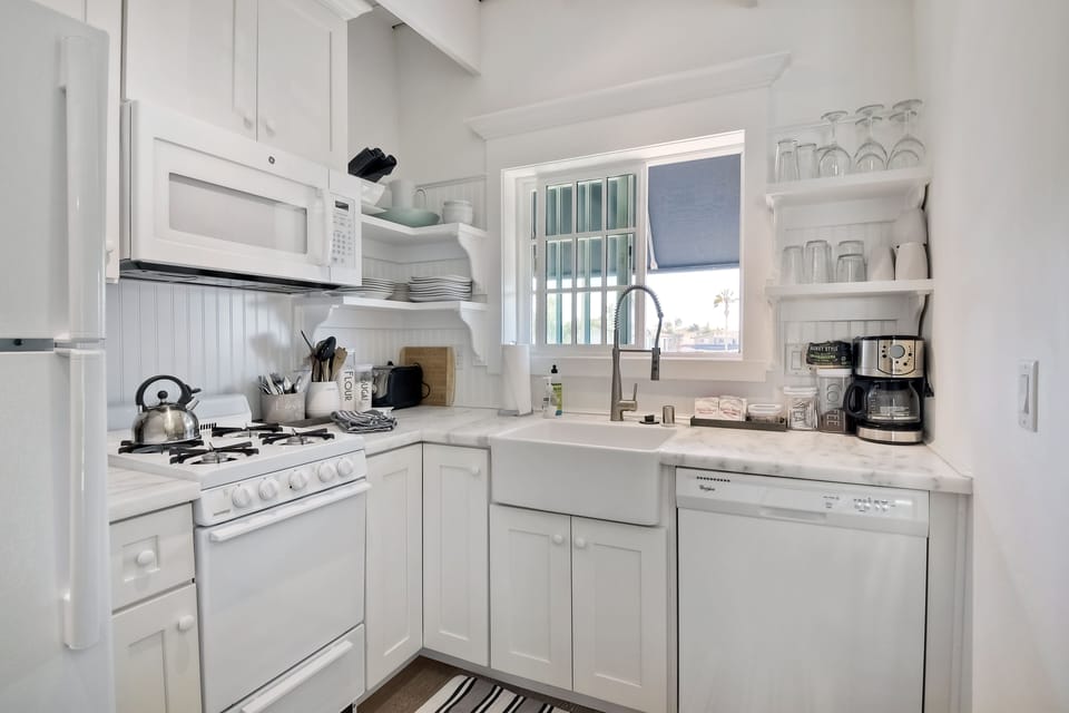 Kitchen area with gas stove/oven.  Lots of dishes, pots and pans.