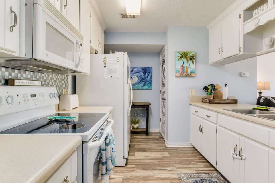 Full kitchen with bar seating, offering a spacious and convenient setup for cooking, dining, and relaxing during your Perdido Key beach getaway.