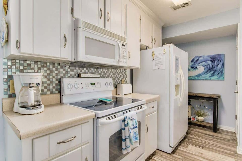 Full kitchen with bar seating, offering a spacious and convenient setup for cooking, dining, and relaxing during your Perdido Key beach getaway.