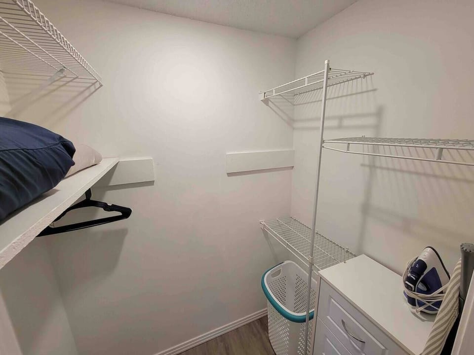 Master bedroom closet. Ironing board and iron.  Extra pillows and blankets provided in each bedroom.