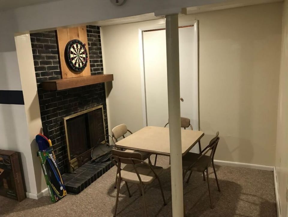 Sitting area in rec room with dartboard. Fireplace is non-functional.