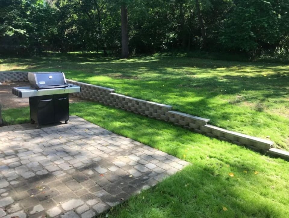 Back yard with patio and gas grill.