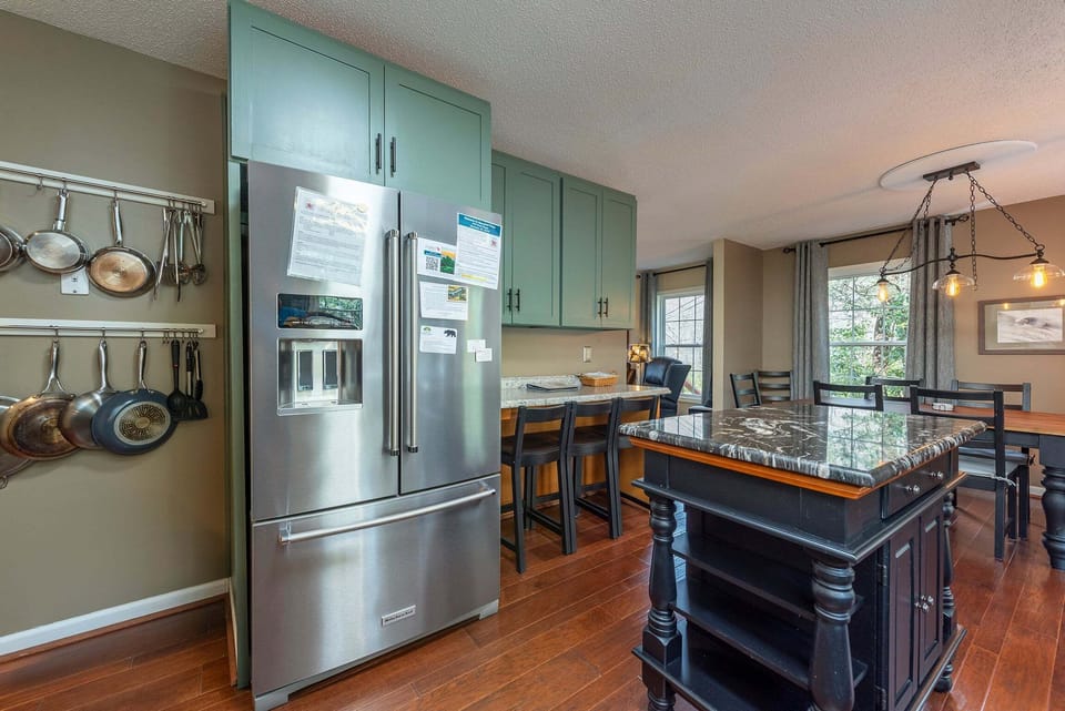 Updated kitchen with KitchenAid dishwasher, Crock Pot, Blender, Mixer, Drip-style coffeemaker, induction range with dual ovens, and bar seating for 3.