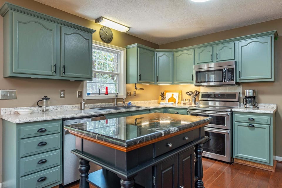 Updated kitchen with KitchenAid dishwasher, Crock Pot, Blender, Mixer, Drip-style coffeemaker, induction range with dual ovens, and bar seating for 3.